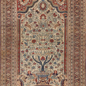 Traditional rug in beige, red, and blue featuring a detailed floral tree-of-life motif within an arched frame.