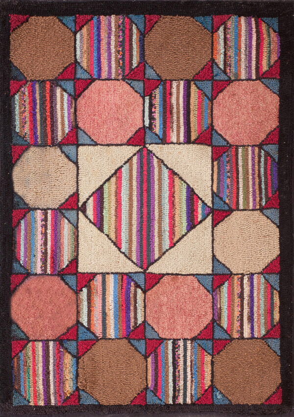 A colorful geometric hooked rug with a central diamond pattern surrounded by solid and vertically striped blocks.