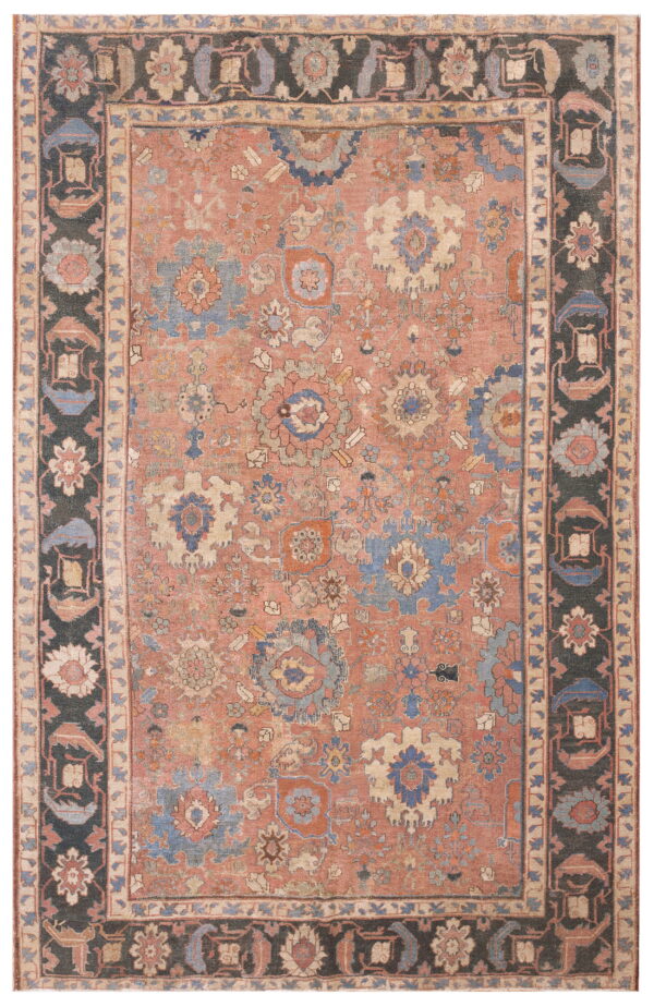 Ornate rug featuring a faded terra cotta field with blue florals and a contrasting dark patterned border.