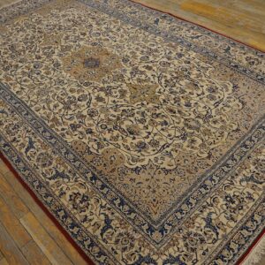 Detailed low-pile rug in cream, blue, and tan traditional patterns on a distressed wooden floor.
