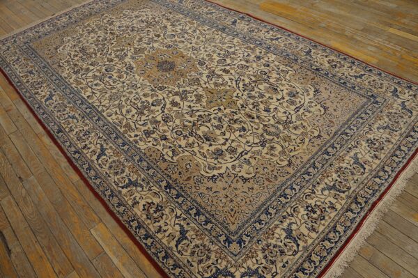 Detailed low-pile rug in cream, blue, and tan traditional patterns on a distressed wooden floor.