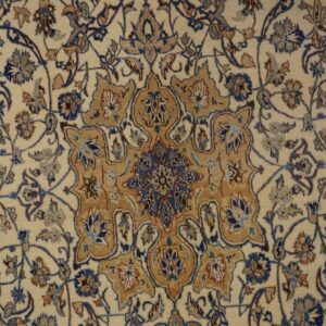 Cream rug with detailed traditional floral motifs in blue, tan, and dark brown accents.