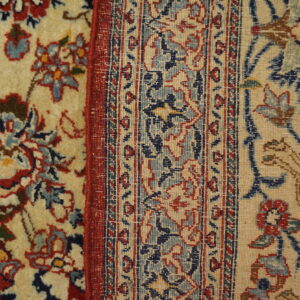 Intricate floral and geometric patterns in red, navy blue, and light blue against a beige background.