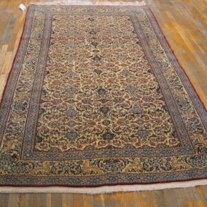 Traditional ivory, blue, and red rug with an all-over floral pattern resting on distressed wood floors.