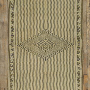 Beige flatweave rug with dark geometric zigzag patterns, a central diamond motif, and meander border.