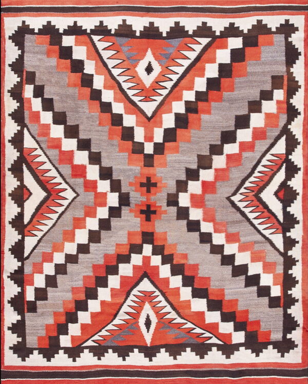 Flatweave rug with a geometric pattern in orange, gray, white, and brown featuring a large serrated central diamond.