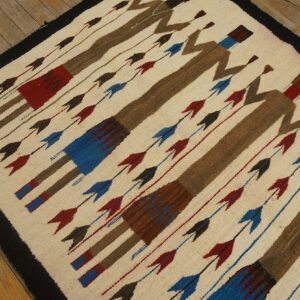 Low-pile rug featuring diagonal brown figures and colored arrows on an off-white ground and wood floor.