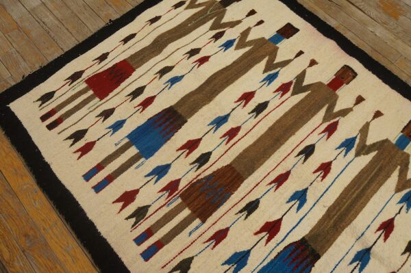 Low-pile rug featuring diagonal brown figures and colored arrows on an off-white ground and wood floor.