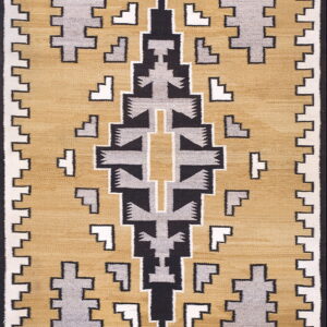 A rug featuring a geometric stepped pattern in black, gray, and white on a mustard yellow field.