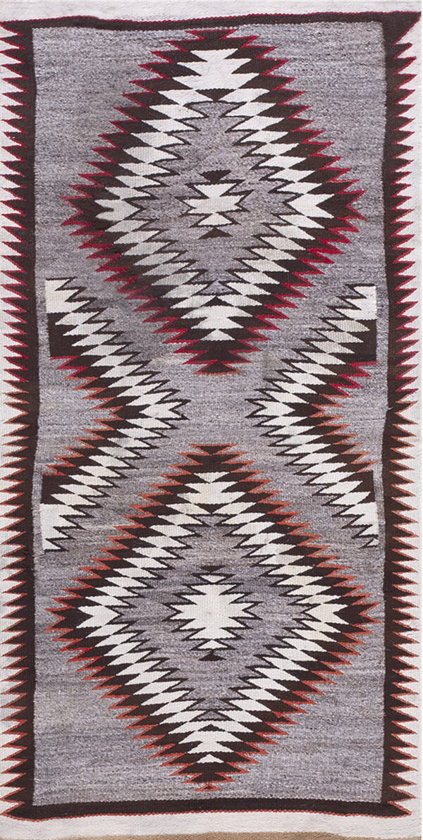 Geometric flatweave rug runner with large gray, white, and red zigzag diamond motifs.