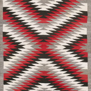 Flat woven rug featuring bold red, black, gray, and white geometric zigzag patterns within a gray border.