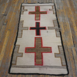 Flatwoven cream and geometric runner with brown and black crosses, displayed on a distressed wooden floor.