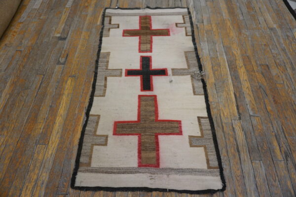 Flatwoven cream and geometric runner with brown and black crosses, displayed on a distressed wooden floor.