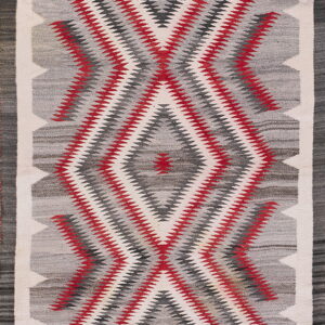 Flat-woven runner rug featuring a serrated diamond pattern in gray, white, red, and charcoal.