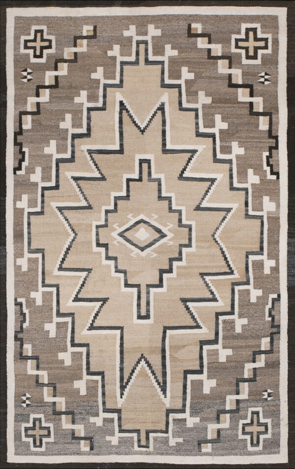 Flatwoven geometric rug featuring large stepped shapes in beige, gray, white, and black.