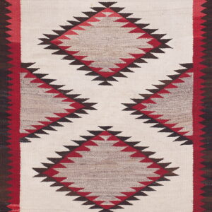 Flatweave rug with serrated red, brown, and natural-toned diamonds on a cream center field.