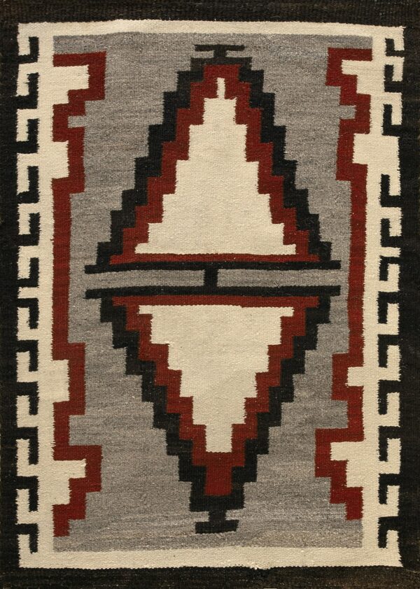 Flatwoven rug featuring a central stepped diamond in cream, gray, black, and reddish-brown with geometric borders.