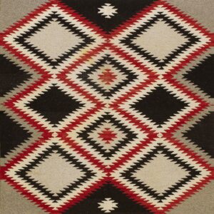 Woven rug with bold stepped diamond designs in black, red, gray, and off-white colors.