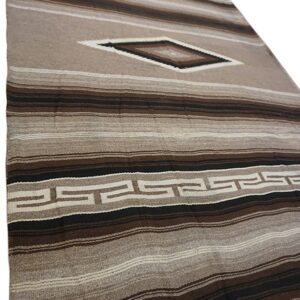 Brown and tan striped rug with a central diamond shape and repeating geometric border pattern.