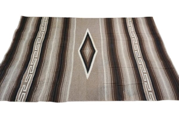 A brown, beige, and black striped rug with a central diamond motif and two geometric border stripes.