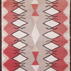 Geometric flatweave rug in red, taupe, and cream, featuring prominent diamond and hourglass shapes.