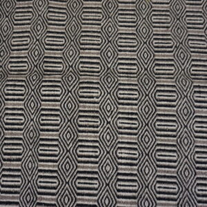 Low-pile rug with alternating black, gray, and light geometric hexagonal and diamond repeating motifs.
