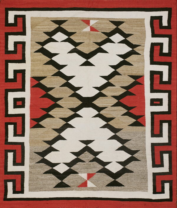 Geometric rug with red, black, and cream meander borders framing a flat-woven field of serrated diamonds.