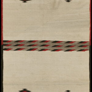 Low pile cream rug featuring bold red, black, and gray serrated zig-zag and diamond patterns.