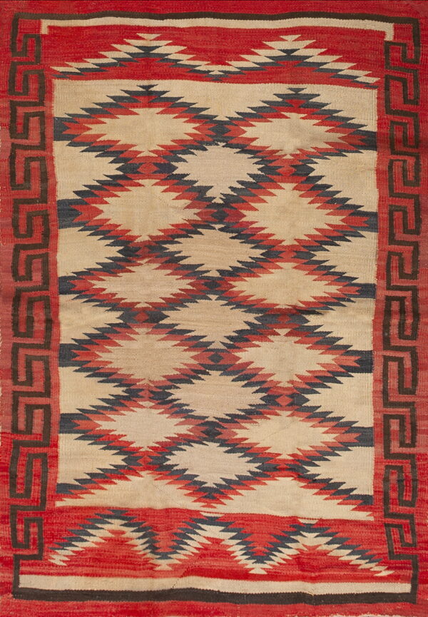 Flatwoven rug in red, tan, and dark gray with geometric diamond patterns and a fret border design.