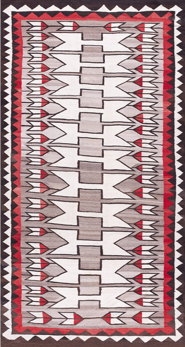 Flat-weave rug with white, gray, and red geometric motifs, framed by a dark brown and white zigzag border.