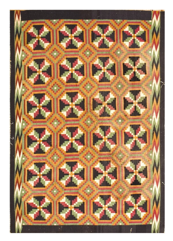 Black, orange, red, and green flatweave rug with repeating geometric squares and zigzag side borders.