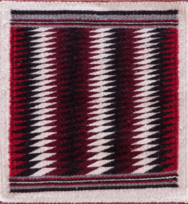 Antique allover geometric wool flat weave multicolor jewel tones 1930s square rug 1 Small flat-weave rug featuring cream, black, red, and maroon serrated diamond stripes on wood floor.
