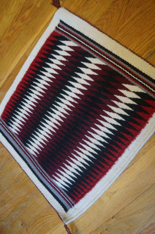 Antique allover geometric wool flat weave multicolor jewel tones 1930s square rug 6 Geometric square flatwoven rug featuring white, black, and deep red zigzagging diamonds on wood planks.