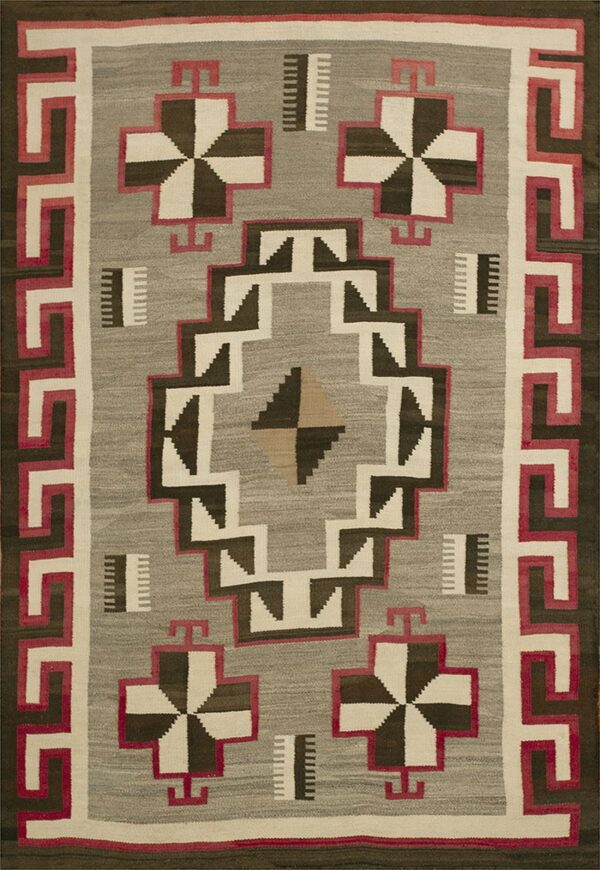 Flatwoven rug in gray, dark brown, and off-white with distinct pink geometric border and central motifs.