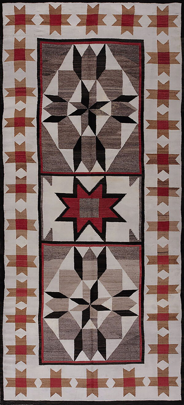 A runner rug featuring geometric star designs in red, black, white, and brown with a flatweave texture.