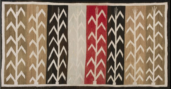 Flat-woven rug featuring white corn stalk motifs across vertical stripes of red, black, beige, and gray.
