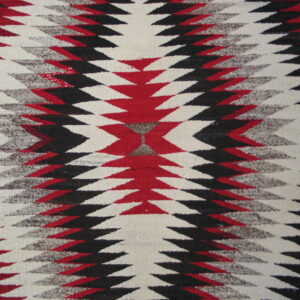 Flatweave rug featuring serrated diamond patterns in red, black, cream, and heathered gray colors.