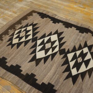Earthy runner rug featuring dark brown and cream stepped geometric diamonds on distressed wood flooring.