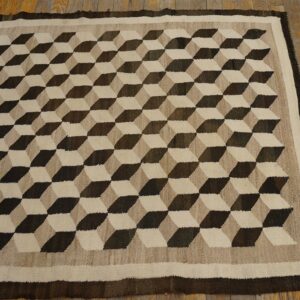 Flatweave rug featuring a dark brown and beige three-dimensional cube pattern on wood flooring.