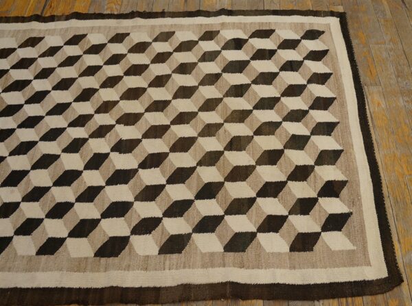 Flatweave rug featuring a dark brown and beige three-dimensional cube pattern on wood flooring.