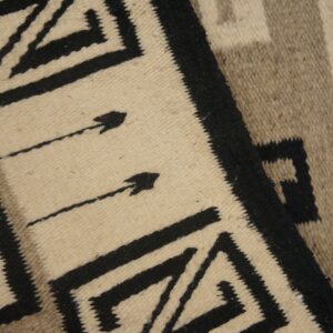 Cream, black, and taupe flatweave rug with bold geometric patterns and visible arrow designs.