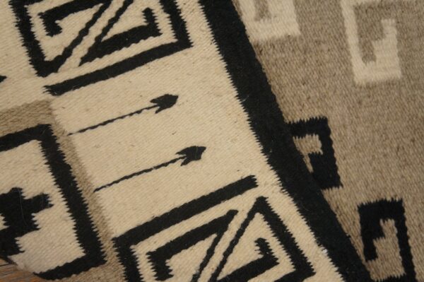 Cream, black, and taupe flatweave rug with bold geometric patterns and visible arrow designs.