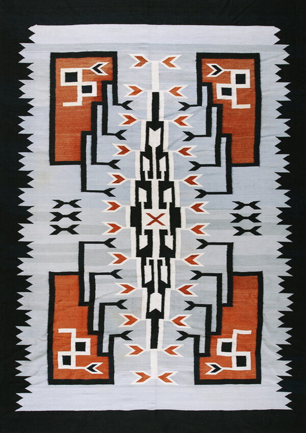 Geometric textile in gray, rust, black, and white featuring stepped patterns and a serrated black edge.