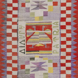 Flatwoven rug with red and cream checkered borders, geometric motifs, and the words "ALAVIA PATRIA."