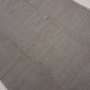 Simple taupe flatweave rug featuring stepped cream borders on distressed wood flooring.