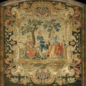 Needlework tapestry framed in wood, featuring a light pastoral scene surrounded by a dense, dark green floral border.