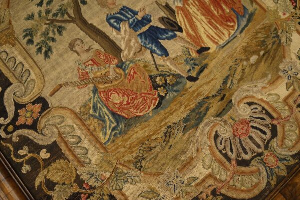 Detailed low-pile textile featuring a classical scene of figures, trees, and elaborate gold and brown scrollwork.