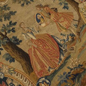 Detailed flat-woven rug showing figures and trees, utilizing blue, rust, gold, and green colors.