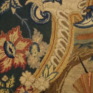 Framed low-pile textile featuring detailed gold, red, and blue floral scrollwork on a dark green background.