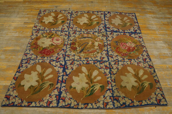 Floral tapestry rug with nine medallions featuring lilies and roses, set on distressed wooden planks.